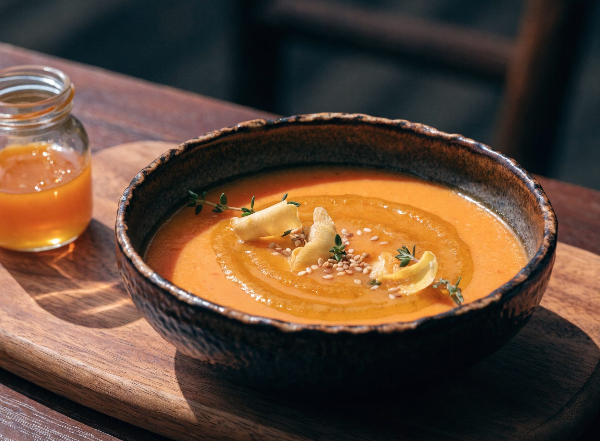 Cremige orange Möhren-Ingwer-Suppe mit Honig-Senf-Sahne und gerösteten Sesamsamen