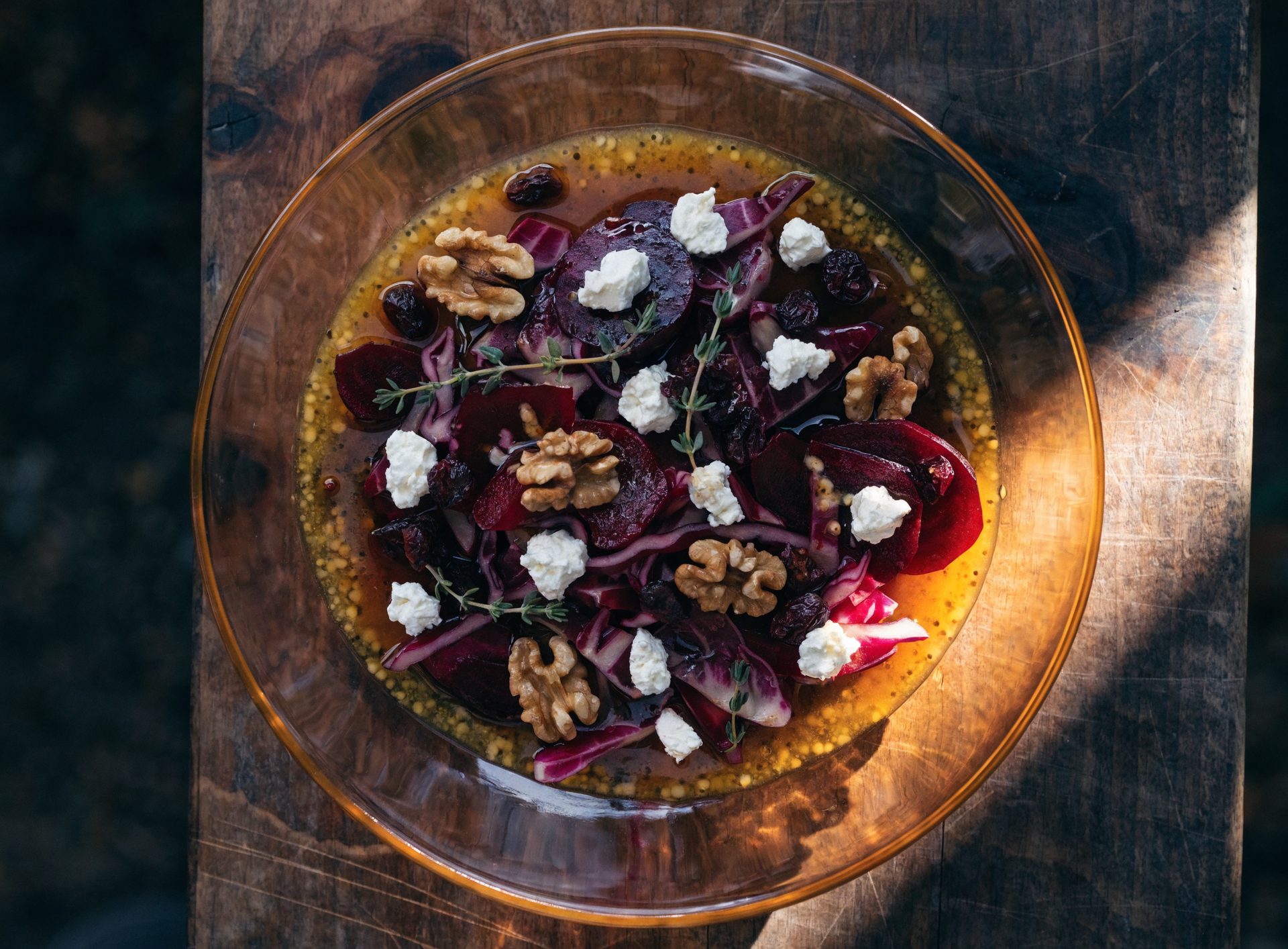 Bunter Wintersalat mit Rotkraut, Rote Bete, Walnüssen und Ziegenkäse in dunkler Schüssel